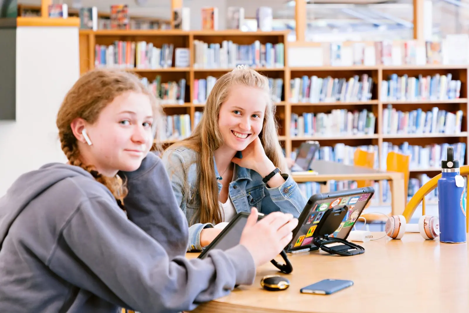 Dos alumnas sonrientes estudiando juntas en la biblioteca de San Domenico School