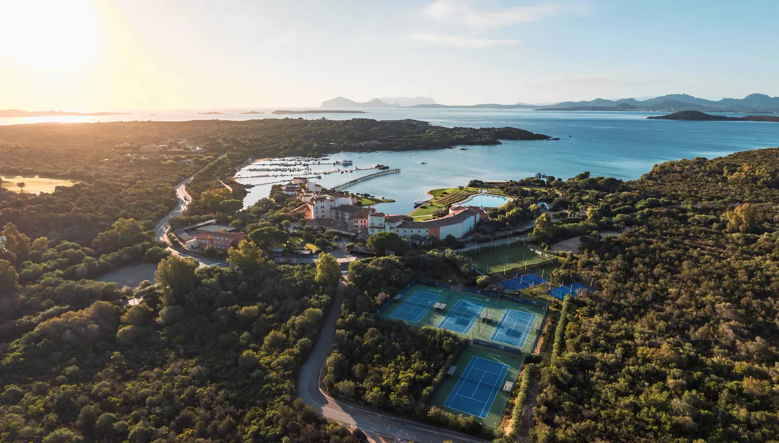 Luftaufnahme bei Sonnenuntergang des Hotel Cala di Volpe, der Tennisplätze und der Küste der Costa Smeralda auf Sardinien.