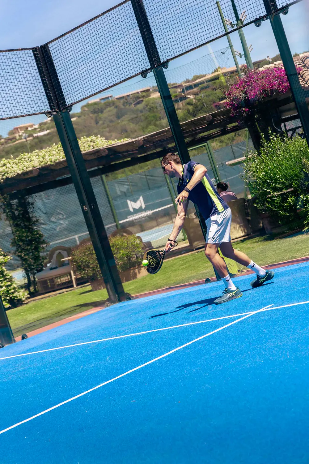 Spieler schlägt einen Padelball auf dem Platz des Mouratoglou Tennis Center Cala di Volpe auf Sardinien.