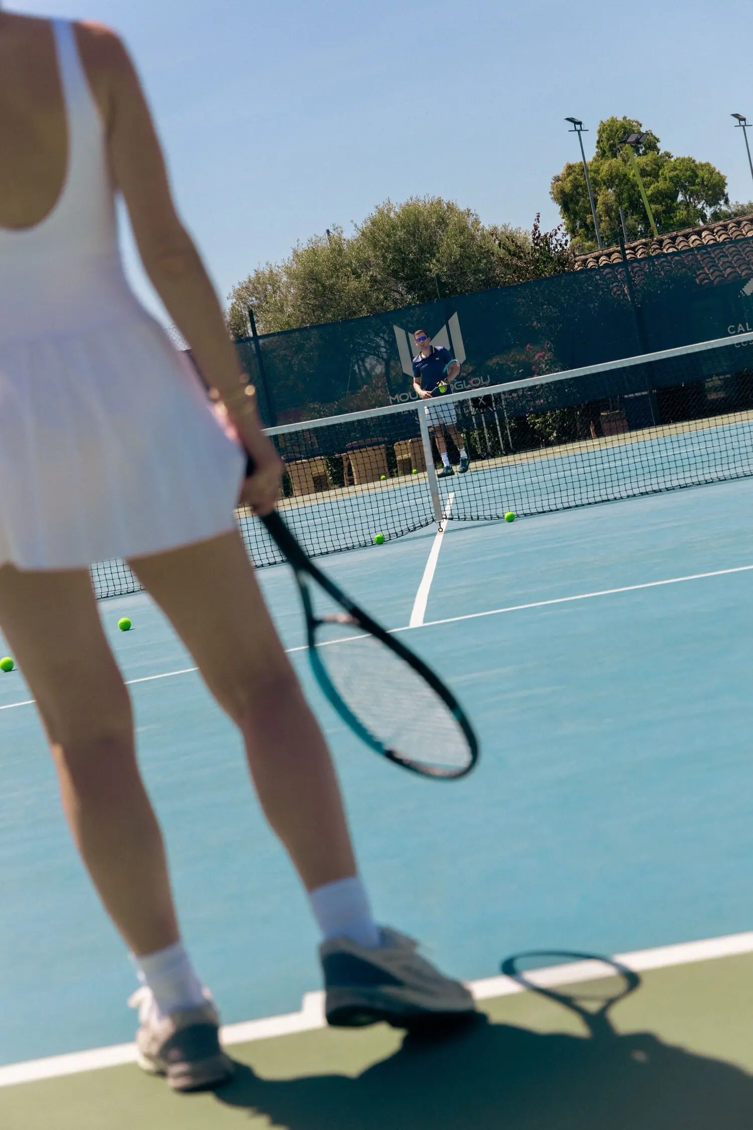 Player holding her racquet on a hard court at Hotel Cala di Volpe