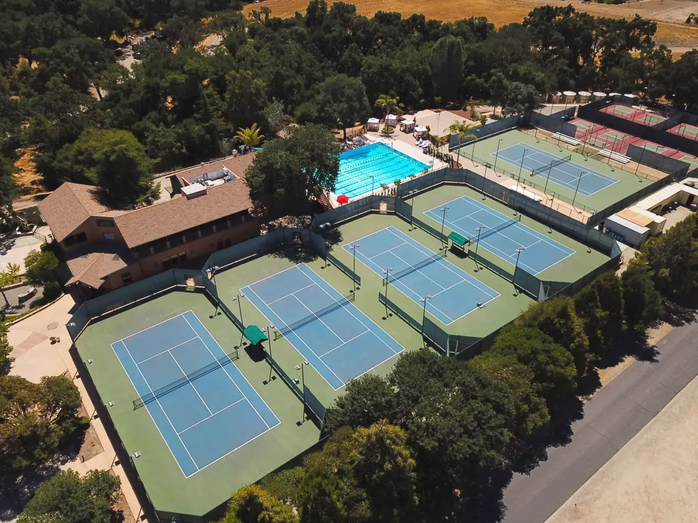 Vista aérea de las pistas de tenis y la piscina entre los árboles del Mouratoglou Tennis Center Templeton