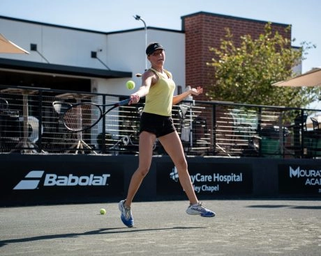 Joueur adulte frappant un coup droit sur un court extérieur du Mouratoglou Tennis Center Templeton.