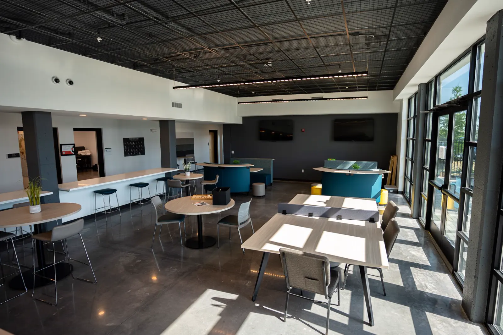 Helle Spielerlounge mit Tischen und Bildschirmen an der Mouratoglou Academy Zephyrhills