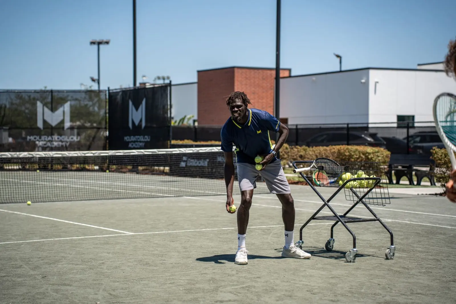 Coach di tennis lancia palle durante un allenamento alla Mouratoglou Academy Zephyrhills