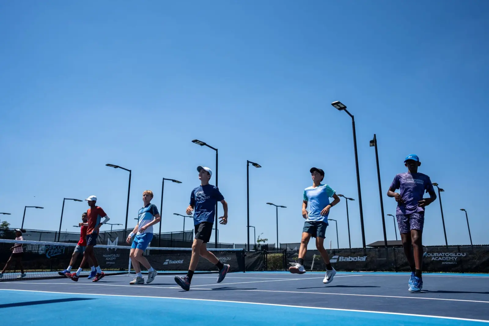 Gruppe von Tennisspielern beim Joggen während eines Outdoor-Fitnesstrainings an der Mouratoglou Academy Zephyrhills