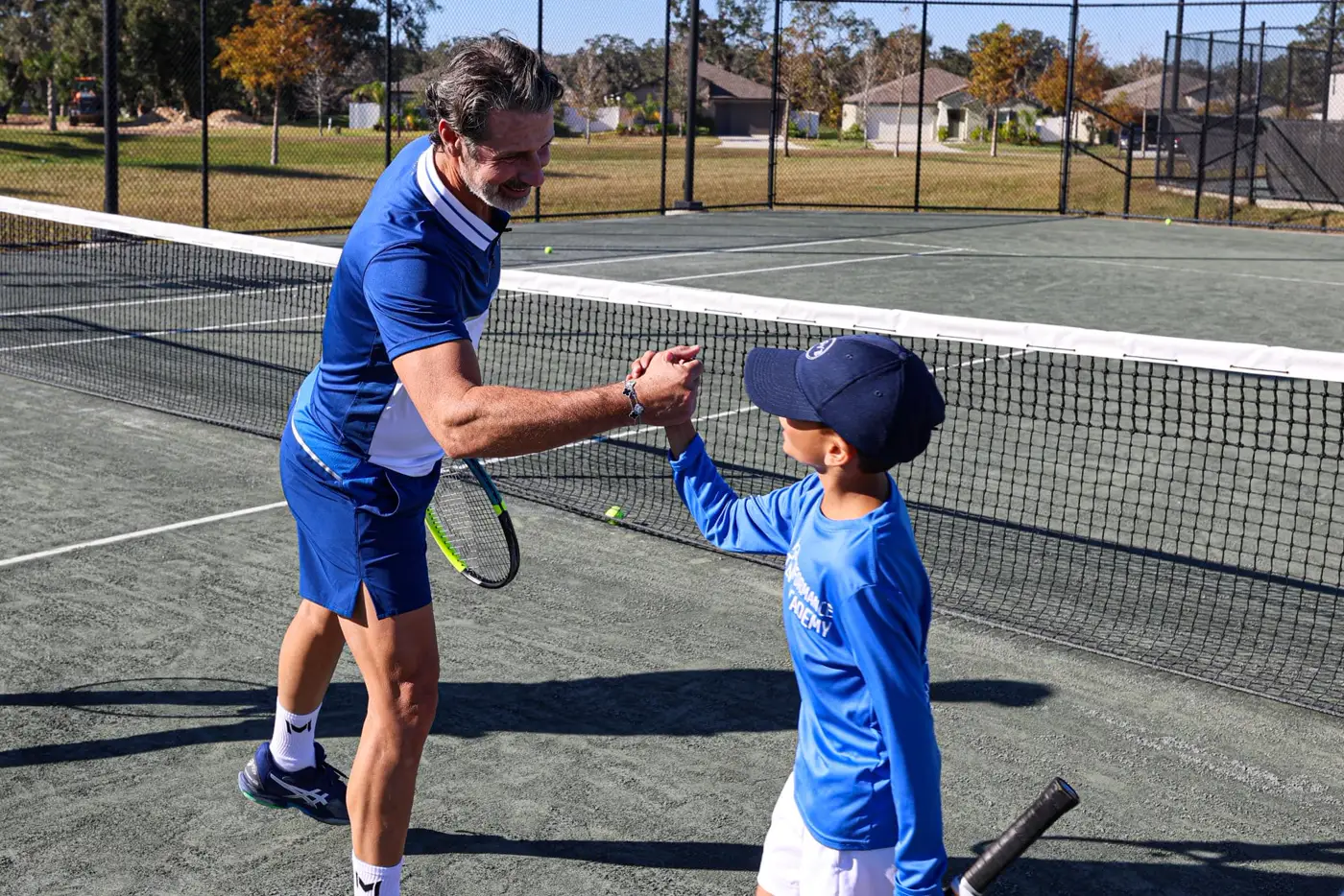 Patrick Mouratoglou allena un bambino su un campo da tennis alla Mouratoglou Academy Zephyrhills
