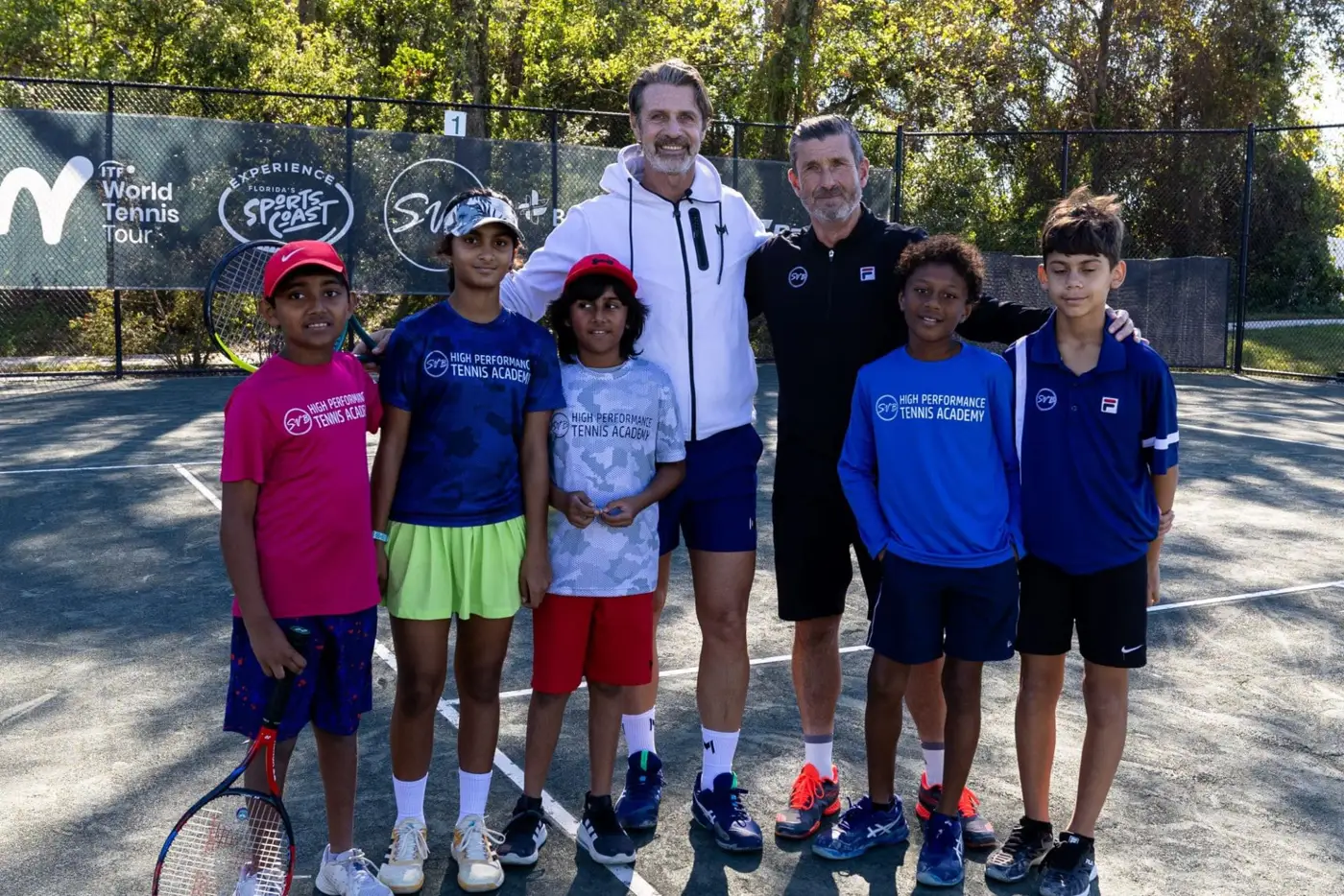 Patrick Mouratoglou mit einer Gruppe junger Spieler auf dem Platz der Mouratoglou Academy Zephyrhills