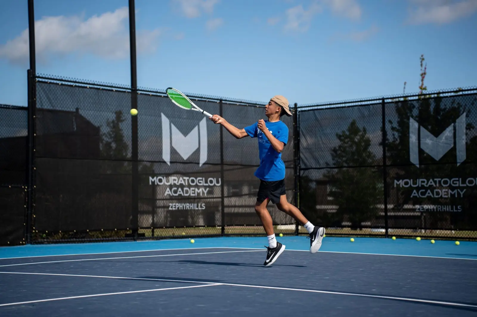 Junior spielt eine Vorhand auf einem Außenplatz der Mouratoglou Academy Zephyrhills