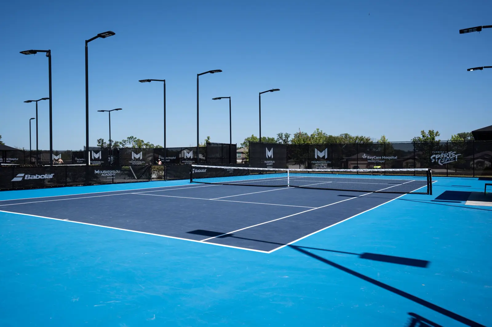 Outdoor tennis court in the sunlight at Mouratoglou Academy Zephyrhills
