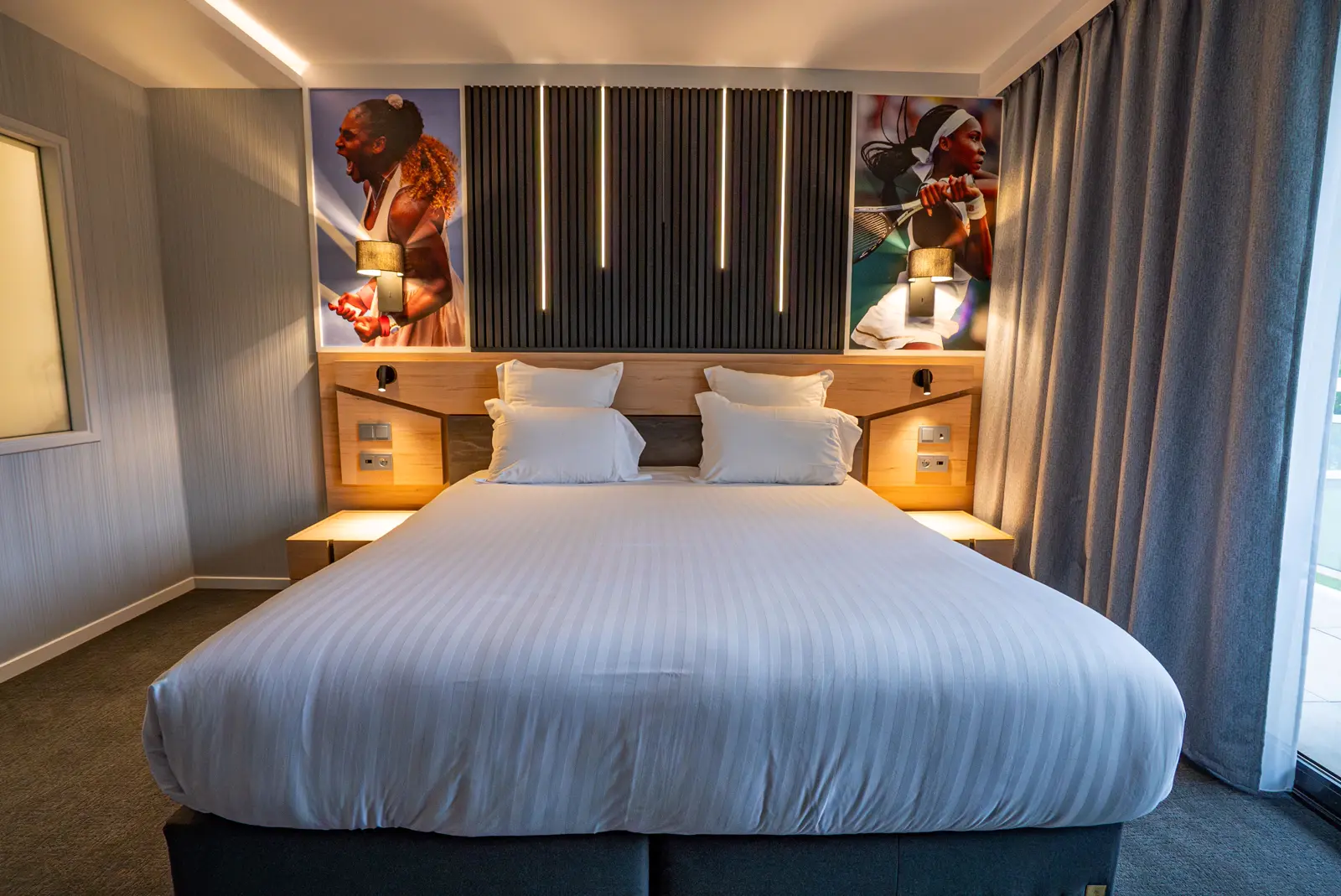 Chambre double à la lumière chaleureuse, ornée d’une œuvre à l’effigie d’un champion de tennis