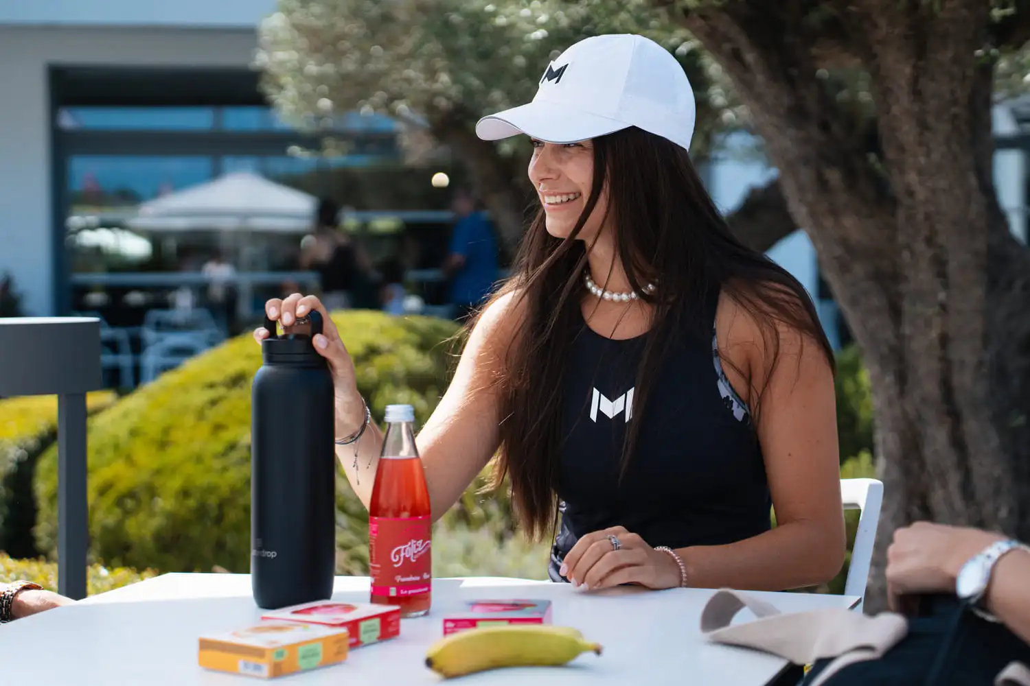 Spieler genießt einen gesunden Snack auf einer sonnigen Terrasse der Akademie