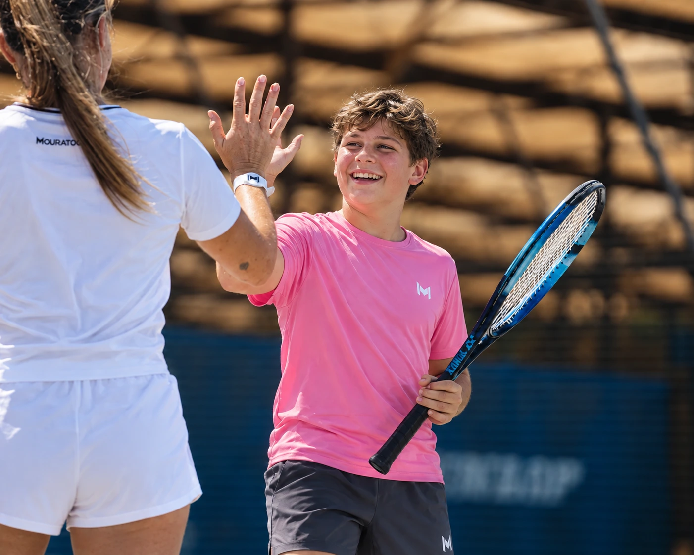 Jeune joueur souriant faisant un check à son coach