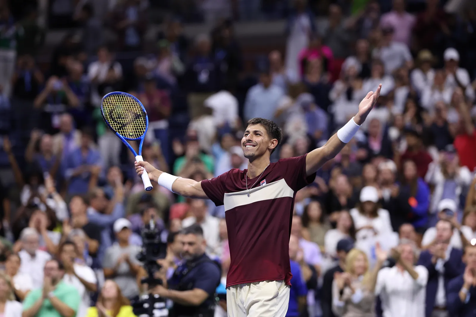 Alexei Popyrin raising his arms to celebrate a win in front of a packed stadium