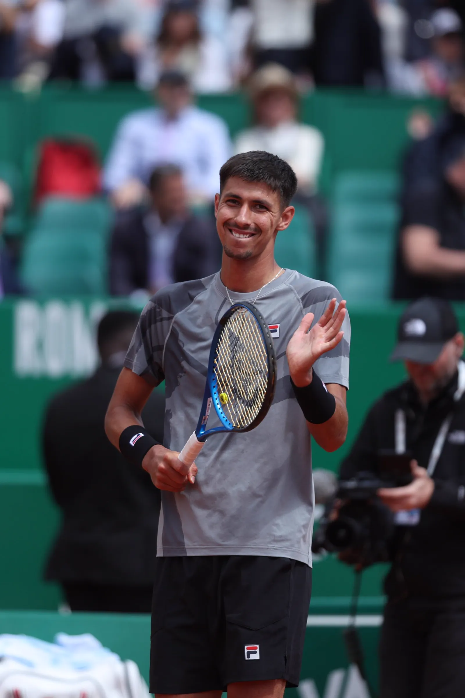 Alexei Popyrin smiling on court after a match