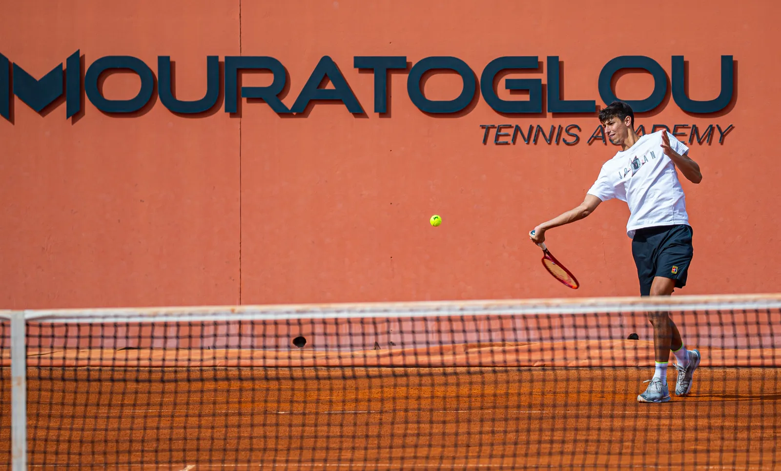 Alexei Popyrin hitting a forehand on clay at the Mouratoglou Academy