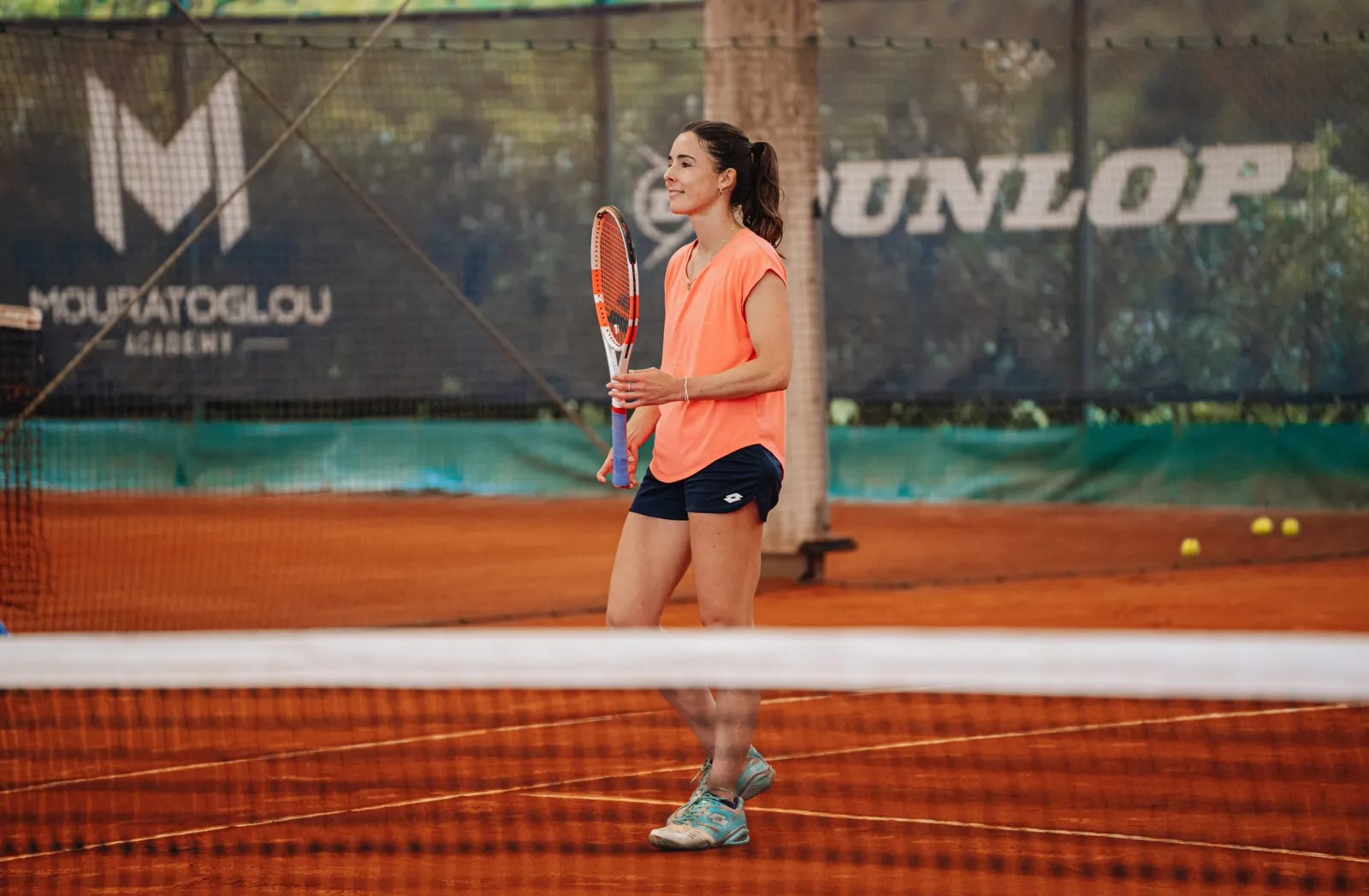 Alizé Cornet am Netz auf einem Sandplatz der Akademie