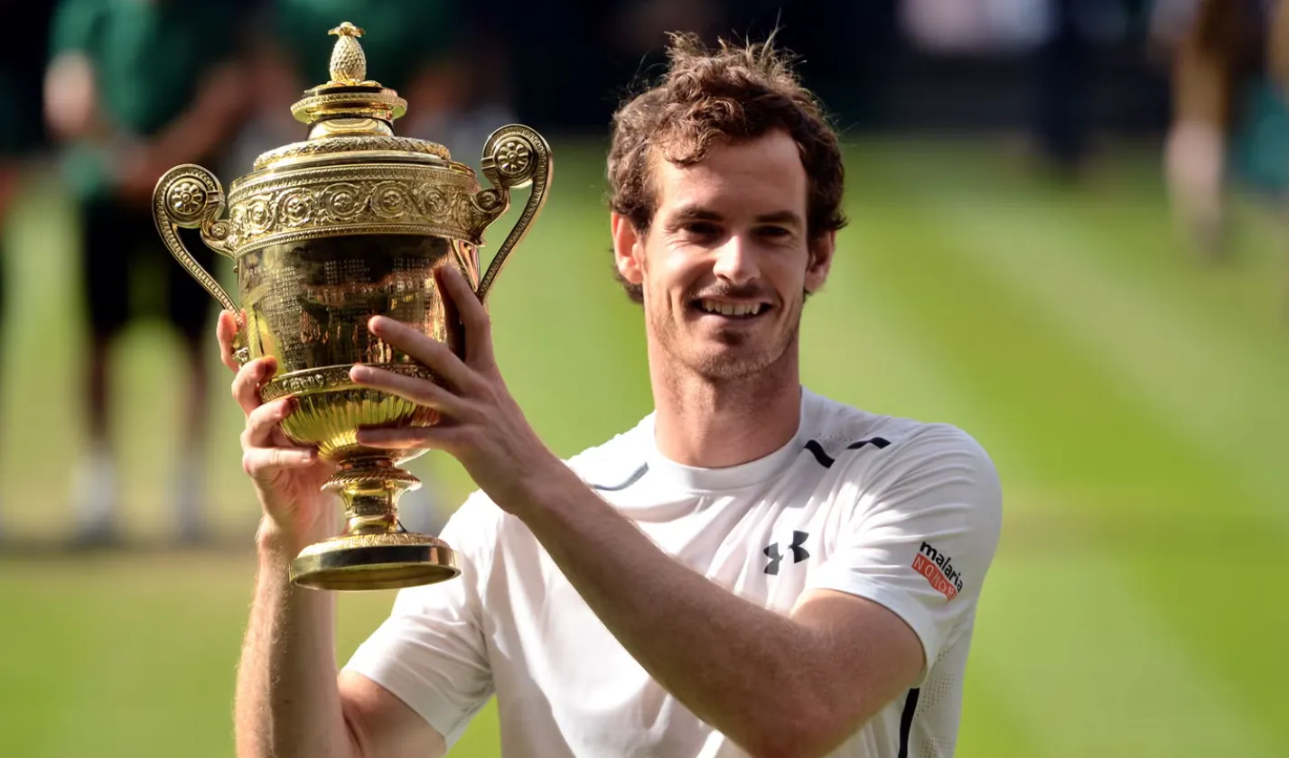 Andy Murray hebt lächelnd die Wimbledon-Trophäe in die Höhe