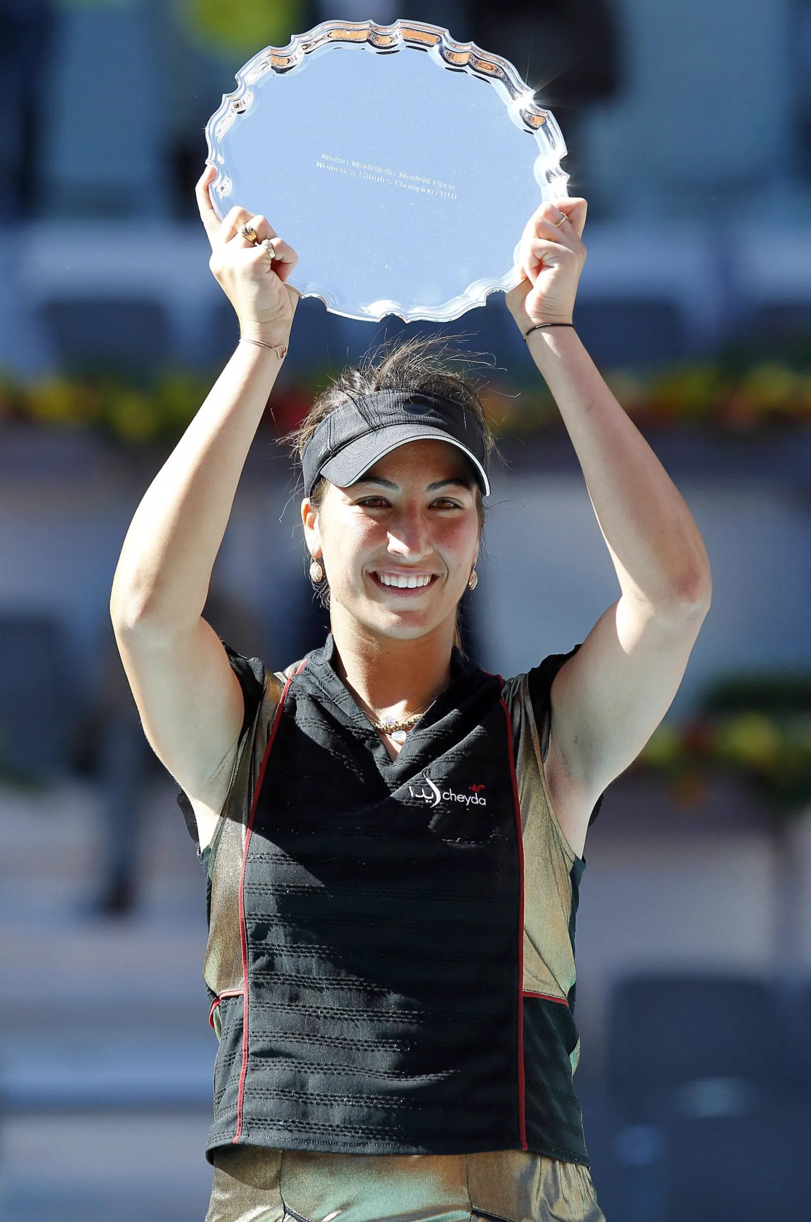 Aravane Rezaï brandissant le trophée de la gagnante au-dessus de sa tête