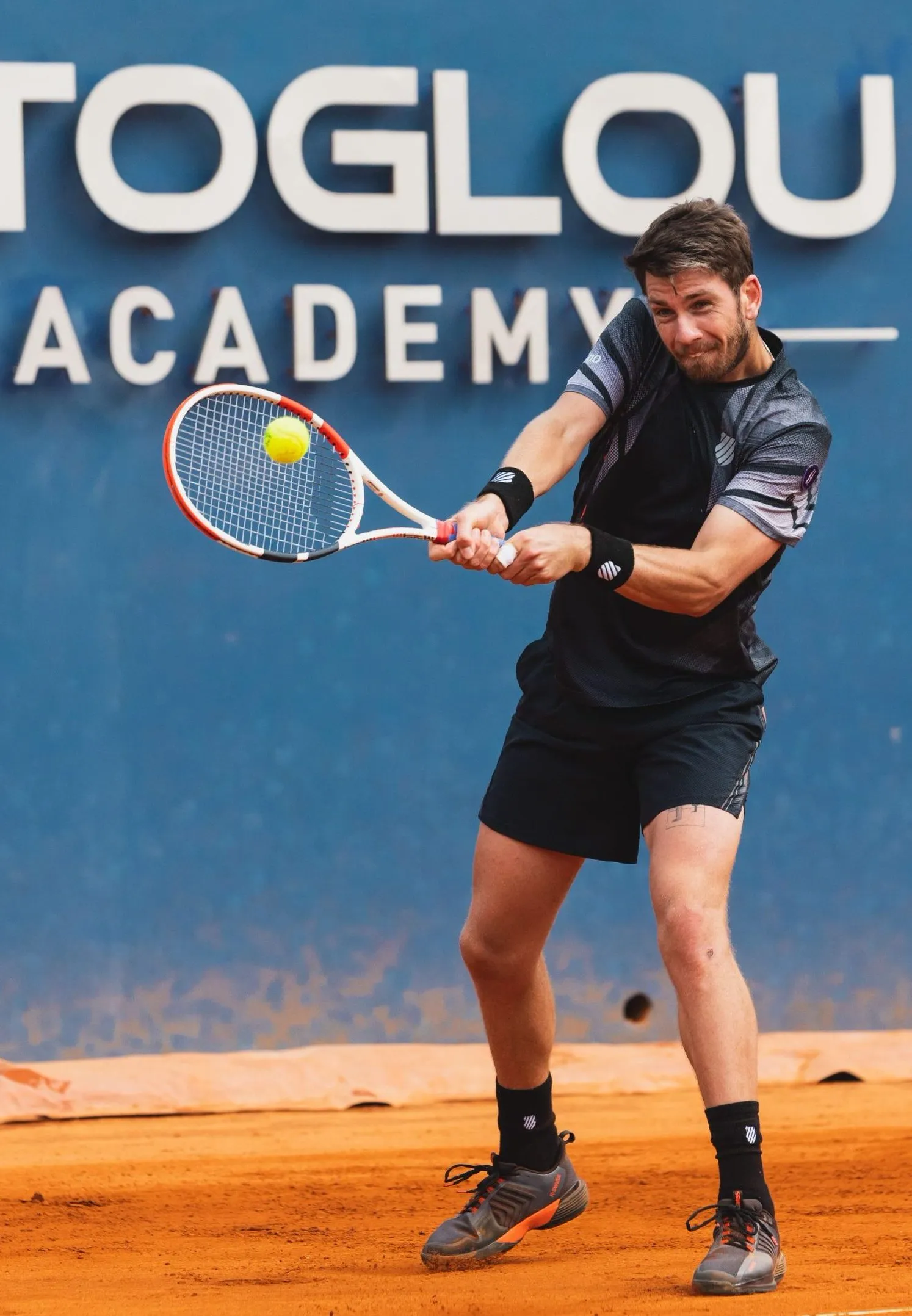 Cameron Norrie frappant un revers sur terre battue à la Mouratoglou Academy