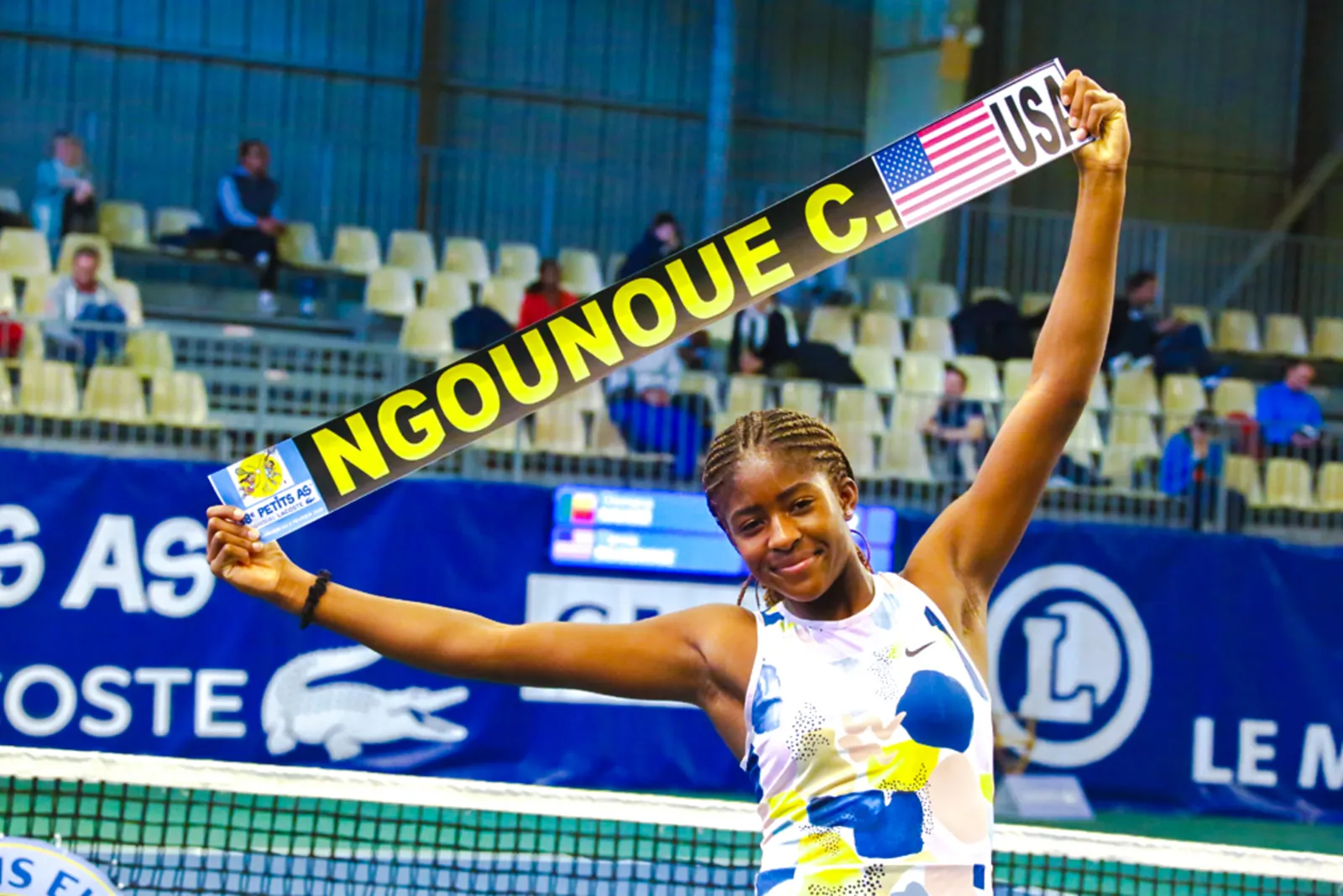 Clervie Ngounoue celebrando en la pista con una pancarta con su nombre