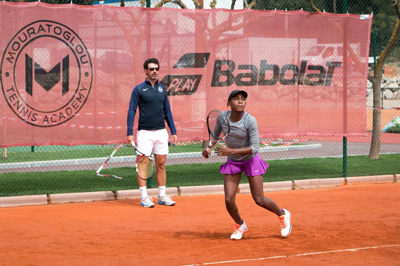 Coco Gauff trainiert mit einem Coach auf Sand