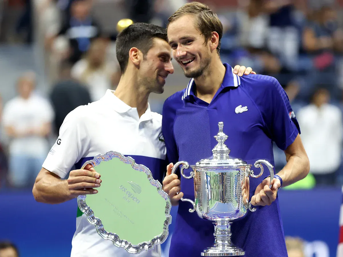 Daniil Medvedev hält die Trophäe der US Open neben Novak Djokovic
