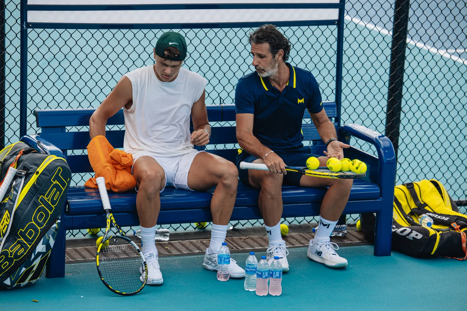 Holger Rune assis sur un banc avec Patrick Mouratoglou pendant l’entraînement