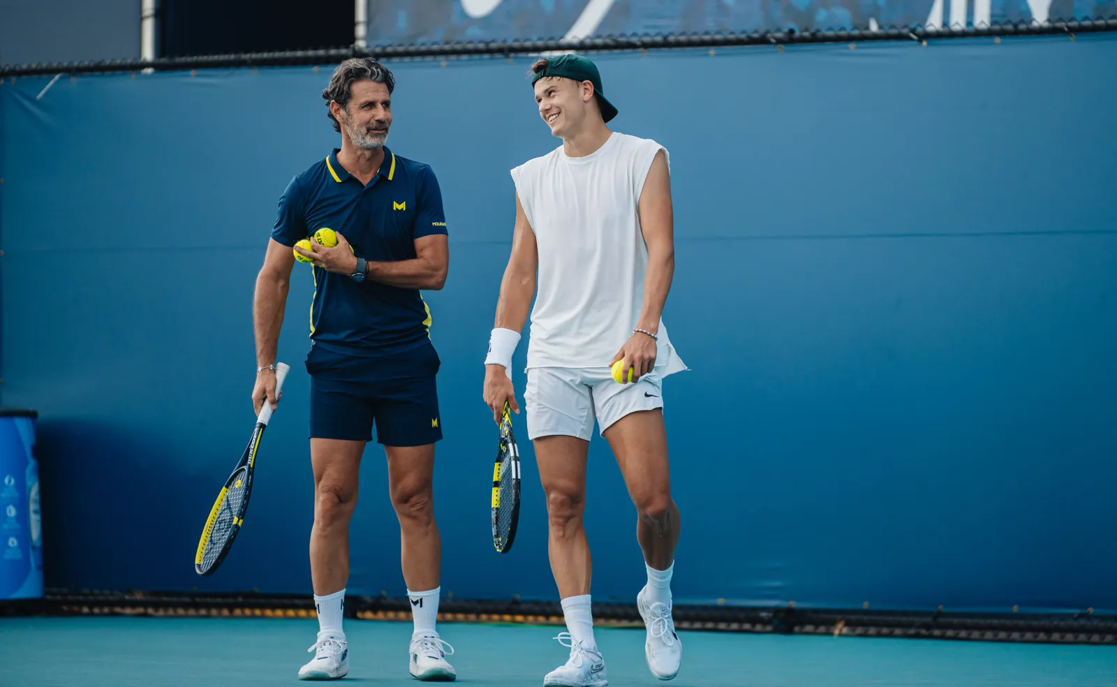 Holger Rune et Patrick Mouratoglou sur un court en dur de l’académie