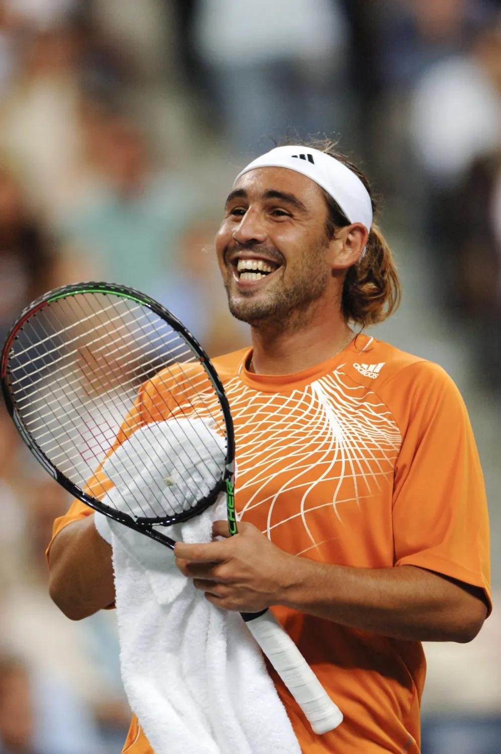 Marcos Baghdatis smiling on court with his racket