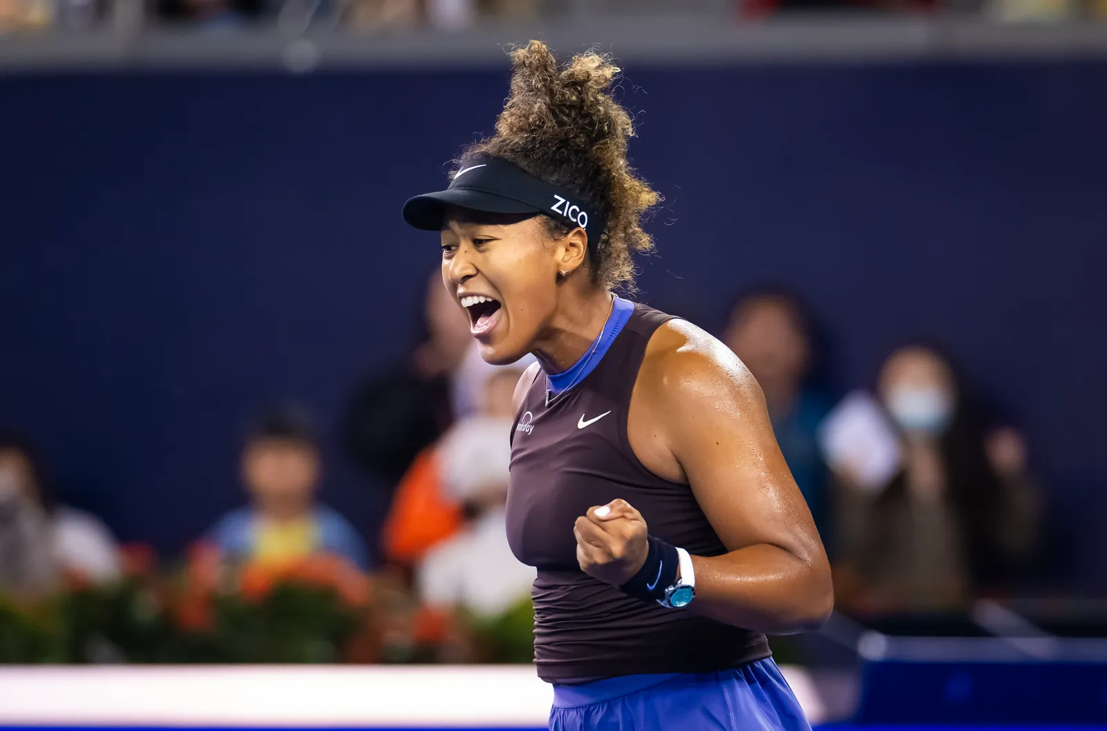 Naomi Osaka shouting and clenching her fist after winning a point