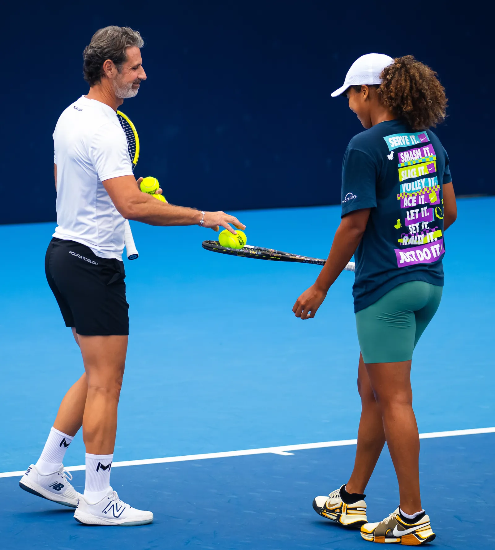 Naomi Osaka training with Patrick Mouratoglou on a blue court
