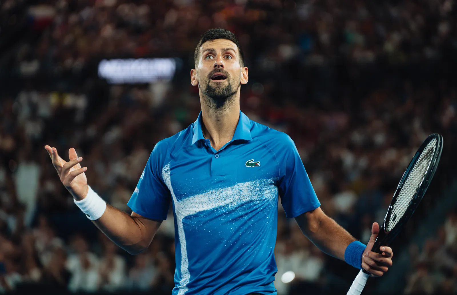 Novak Djokovic gesturing towards the crowd during a night match