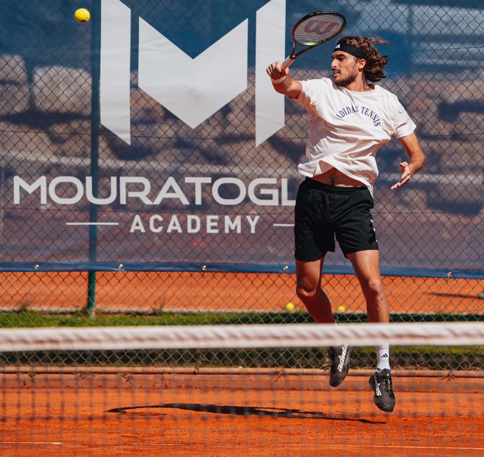 Stefanos Tsitsipas spielt einen Volley auf Sand an der Mouratoglou Academy