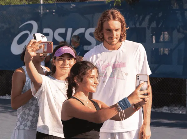 Stefanos Tsitsipas posiert für Selfies mit jungen Spielern an der Akademie